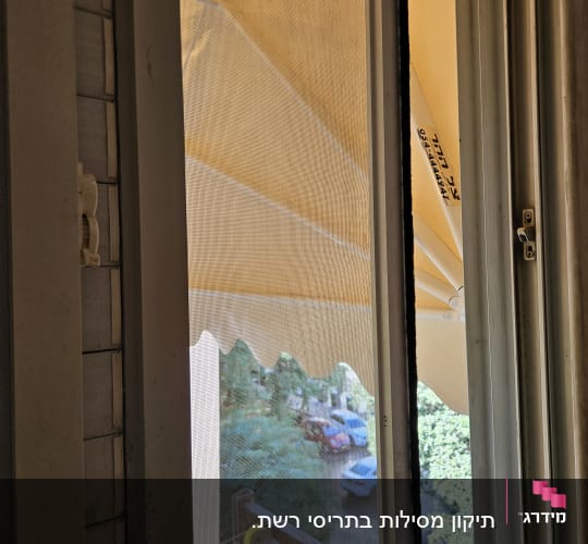 תריסים לבנים ליד חלון עם רשת שקופה
